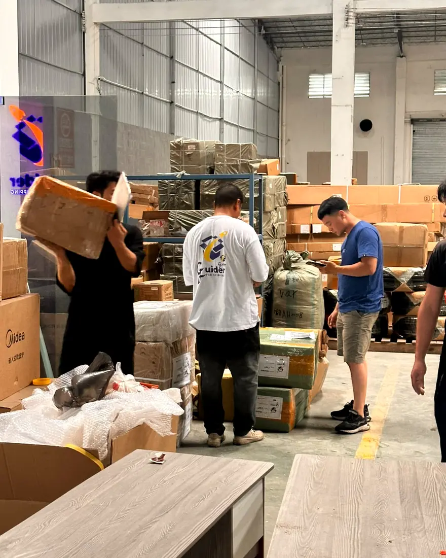 GUIDER staff in company shirts checking and sorting customers' cartons inside the GUIDER warehouse in Guangzhou